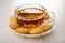 Small biscuits around cup with tea on saucer on wooden table