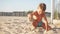 Small blond boy plays with the sand on a pristine beach