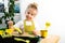 a small blonde girl in an apron is engaged in planting seeds for seedlings, smiling, looking at the camera, the concept