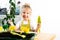 a small blonde girl in an apron is engaged in planting seeds for seedlings, smiling, looking at the camera, the concept