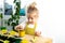 a small blonde girl in an apron is engaged in planting seeds for seedlings, smiling, looking at the camera, the concept