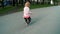 Small blonde girl runs after the ball in the park sunny day rapid slow motion