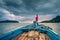 Small blue boat with red cloth bound to the sea in the dark sky