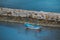 Small blue boat, stone dam and sea in beautiful nature