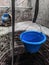small blue bucket from a manual well pump