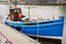 Small Blue Fishing Boat in Harbour on a Rainy Day