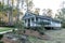 Small blue gray mobile home with a front and side porch with white railing