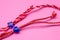 Small blue heart and star on red and white bakers twine with pink background