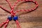 Small blue heart and star on red and white bakers twine with wooden background