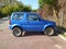 Small blue little 4WD Suzuki Jimny parked