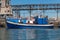 Small blue trawler boat standing by the pier