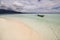 small boat anchored near a beautiful atoll in raja ampat archipelago