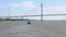 The small boat or barge glides through the river beneath the newly completed giant cable stayed bridge