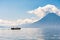 Small boat cruises past San Pedro Volcano, Lake Atitlan, Guatemala