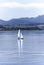 Small boat floating on a lake and mountains in the background