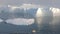 A small boat among icebergs in Disko Bay glacier during midnight sun Ilulissat, Greenland.Studying of phenomenon of global warming