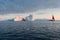 A small boat among icebergs. Sailboat cruising among floating icebergs in Disko Bay glacier during midnight sun Greenland