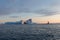 A small boat among icebergs. Sailboat cruising among floating icebergs in Disko Bay glacier during midnight sun Greenland