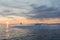 A small boat among icebergs. Sailboat cruising among floating icebergs in Disko Bay glacier during midnight sun Greenland