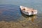 Small boat moored in shallow water with protected seagrass Poseidonis