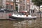 Small boat moored at the side of an urban canal quayside