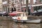 Small boat moored at the side of an urban canal quayside