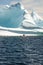 A small boat next to a massive iceberg off the coast of Twillingate Newfoundland