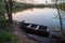 Small boat with oars near the riverbank at sunset.