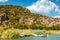 A small boat stands on Lake Koycegiz overlooking the Lycian tomb