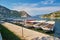 small boats moored in Aegean sea blue lagoon with mountainous islands around, beach at background and turkish flag at top of hill