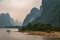 Small boats among tall karst mountains on Li River in Guilin, China