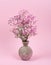 Small bouquet in a vase on a pink background. Tender holiday photo