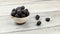 Small bowl with blackberries on gray wood desk