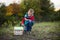 A small boy in an autumn forest collects a wooden house designer