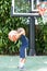 Small Boy child prepares to shoot basketball into basket outdoors