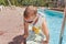 Small boy clambering out of a swimming pool