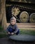 Small boy crouching beside tank