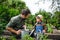 Small boy with father gardening on farm, growing organic vegetables.