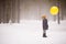 A small boy holding a big yellow balloon in the winter forest. Birthday boy with balloon.  Winter walks with snow