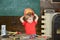 Small boy holding orange protective helmet above his head. Kid playing with working equipment. Preschooler having fun in