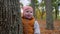 Small boy holds on to big tree in autumn city park, happy childhood outdoors