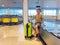 Small boy patiently waits for checked bag at baggage conveyor