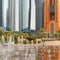 Small Boy Playing in Fountains in front of Abu Dhabi\'s Corniche High Rises