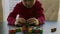 Small boy in a red sweater is playing with the colorful wooden blocks on a table in front of a window.Closeup video.