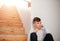 A small boy sitting on the floor by the stairs. Copy space.