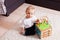 Small boy sitting on a soft rug with toy in his arms