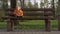 Small boy sitting wooden bench at park. Toddler boy smiling at forest background