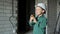A small boy is standing on a construction site and talking on a walkie-talkie