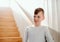 A small boy standing indoors by the stairs. Copy space.