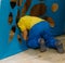 a small boy steps over, climbs, rails, passes into a hole, a cut, an opening in a blue fabric, in matter. child Game. tunnel, laby